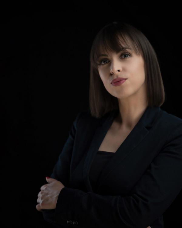 Architektka w czarnej marynarce na czarnym tle, portret ze światłem krawędziowym