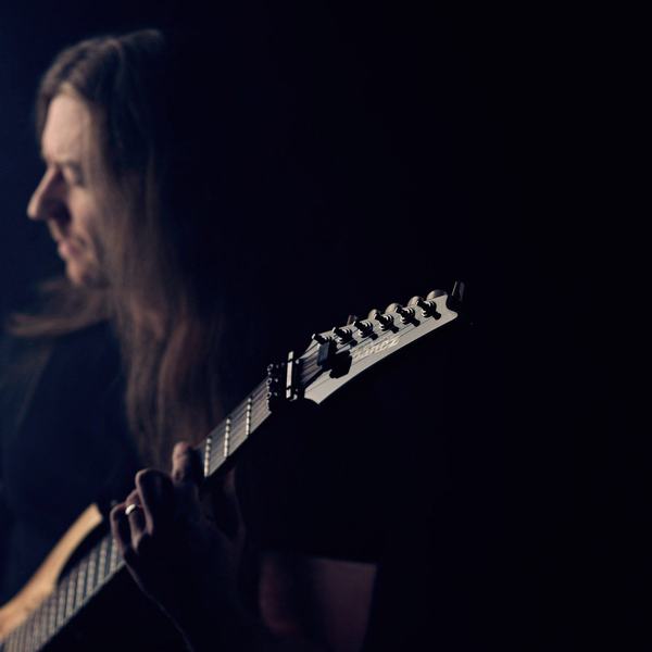 Gitarzysta z profilu w półmroku, sesja wizerunkowa muzyka, studio w Katowicach