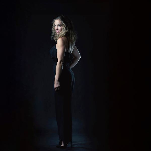 Kobieta w długiej czarnej sukni, portret całej sylwetki na ciemnym tle, studio w Katowicach
