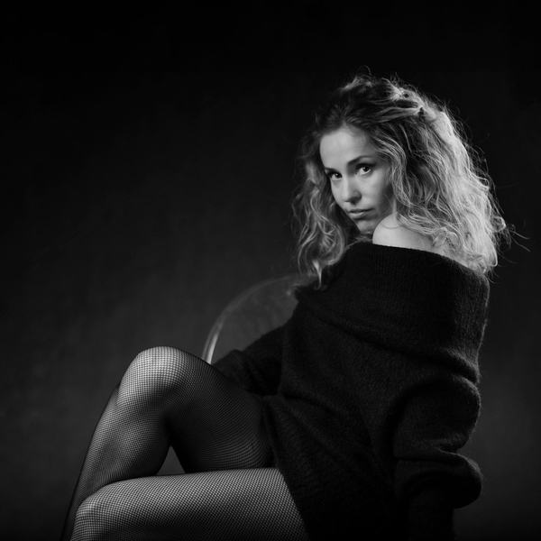 Czarno-biały portret kobiety w swetrze na krześle, studio w Katowicach