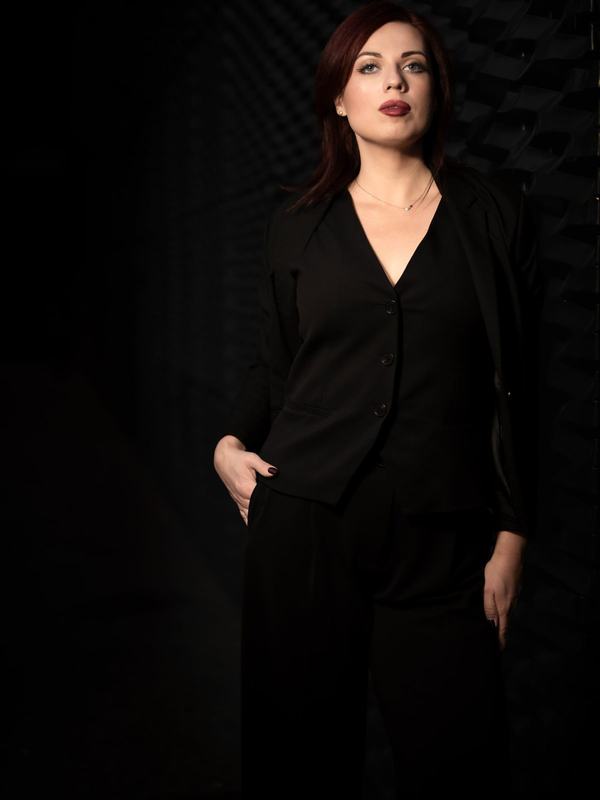 Kobieta w czarnej marynarce na ciemnym tle w mieście, portret wizerunkowy