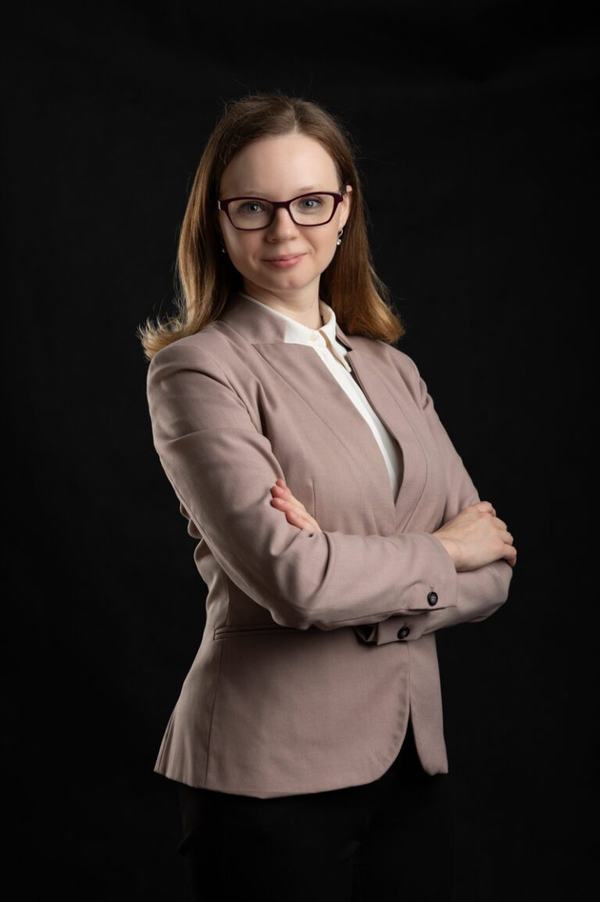 Portret biznesowy: kobieta w okularach i różowej marynarce