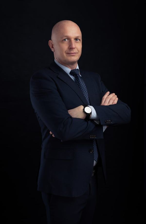Portret biznesowy: mężczyzna w garniturze z rękami skrzyżowanymi