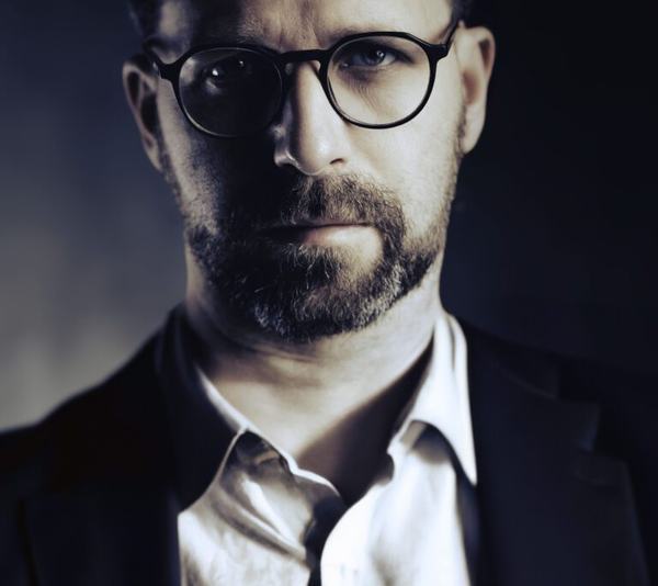 Portret biznesowy: mężczyzna w okularach z brodą, zbliżenie