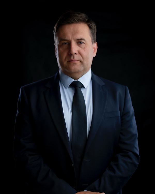 Portret biznesowy mężczyzny w garniturze, ujęcie na wprost, ciemne tło, studio w Katowicach