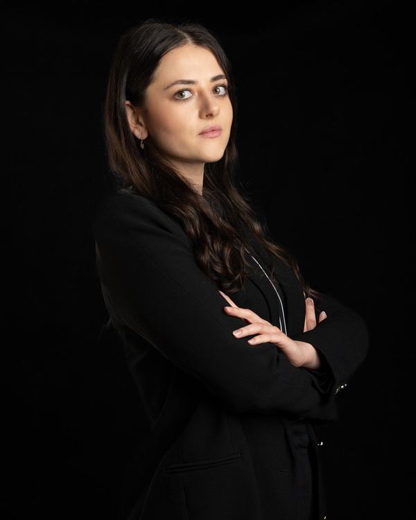 Prawniczka w czarnej marynarce z rękami skrzyżowanymi, portret do strony kancelarii, Kraków