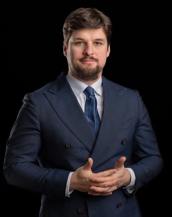 Prawnik w dwurzędowym garniturze z niebieskim krawatem, portret biznesowy na czarnym tle, Katowice
