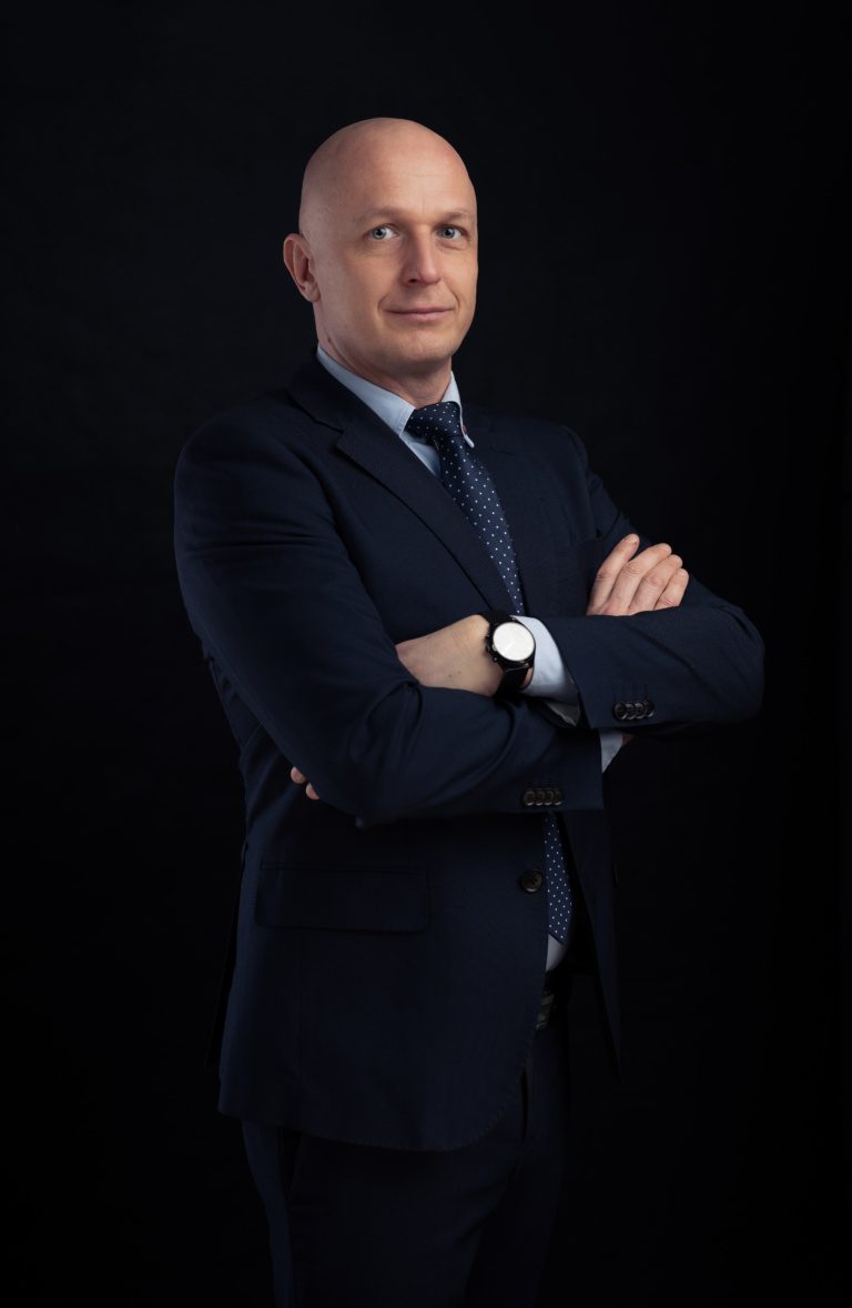 Portret biznesowy mężczyzny w garniturze z rękami skrzyżowanymi