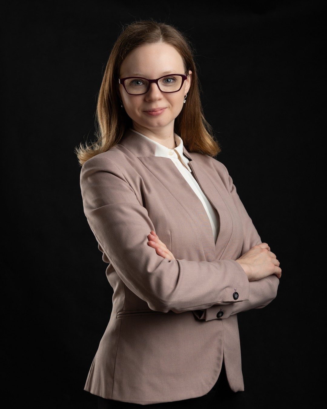 Specjalistka w okularach i jasnej marynarce, portret na ciemnym tle