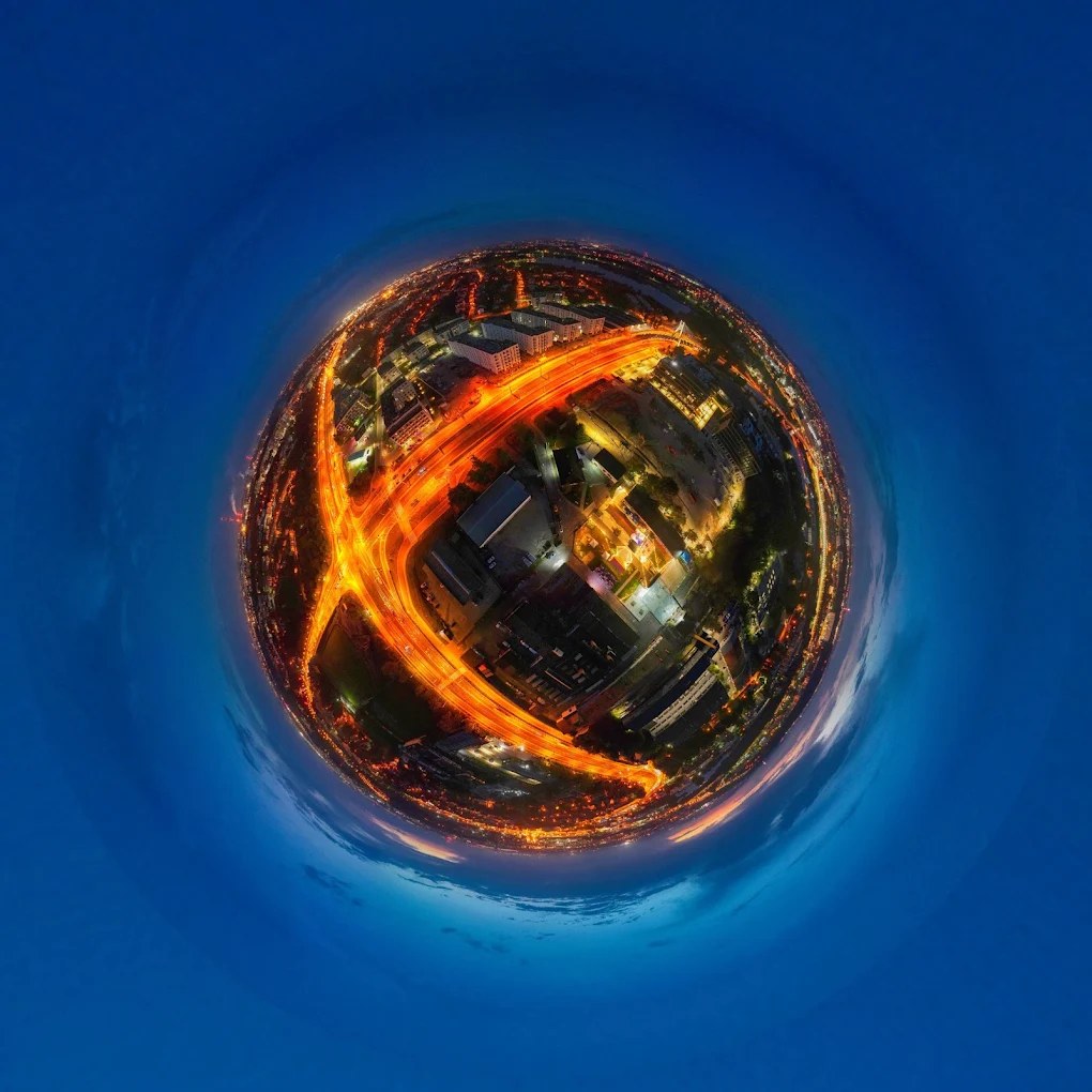 Panorama 360 w formie małej planety: nocne miasto ze świetlistymi smugami ulic